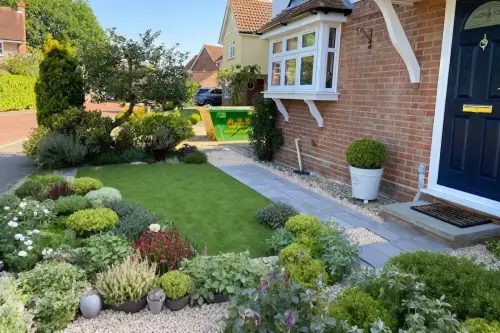 AI Generated Designs Front yard improvements. With minimal effort, some pebels and pots and plants to one corner of your yard, you can create a friendly space to welcome your guests.